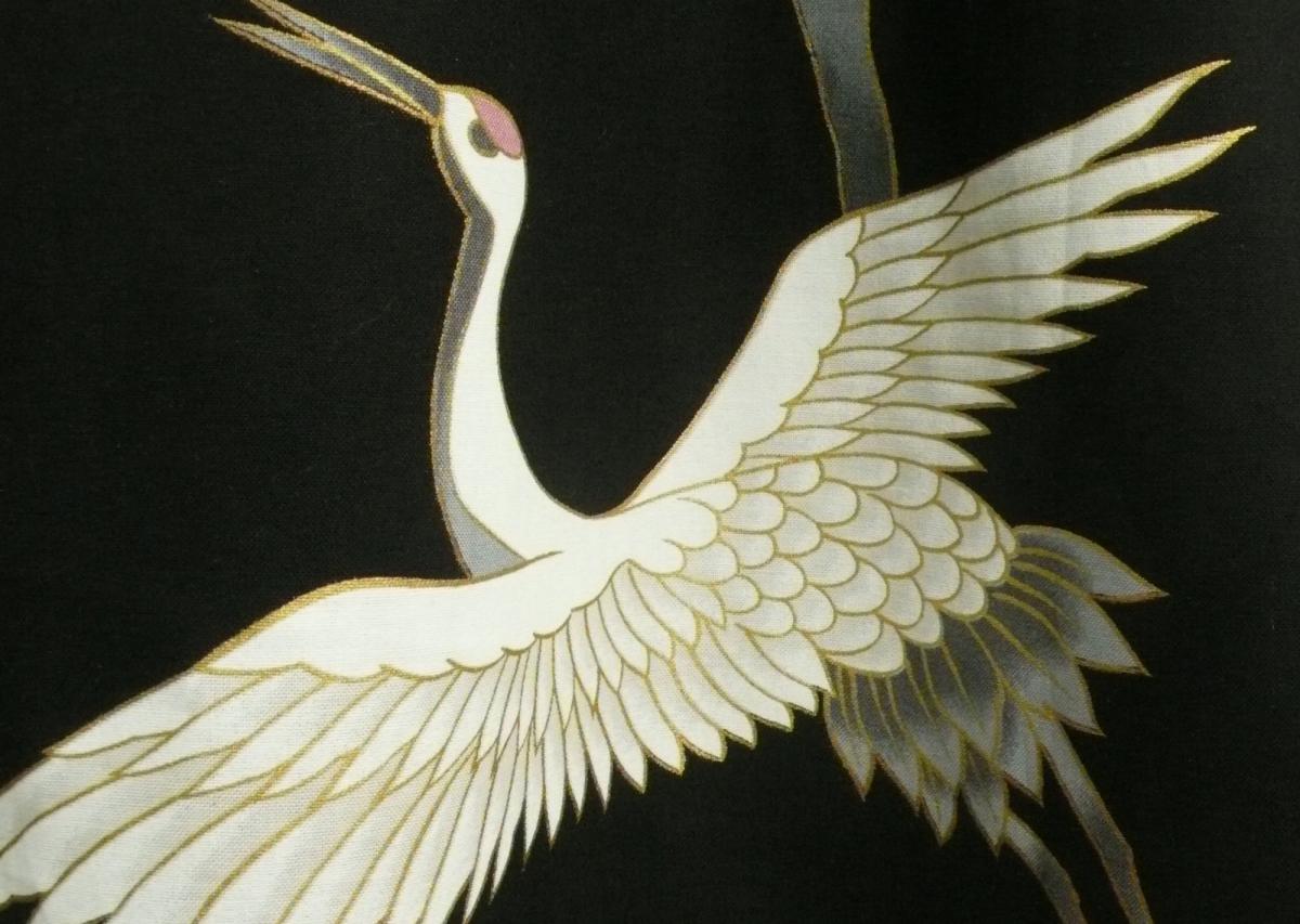 Detailaufnahme der goldenen Kraniche auf schwarzem Kimono